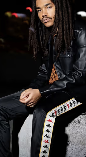A man wearing a pair of black Kappa pants