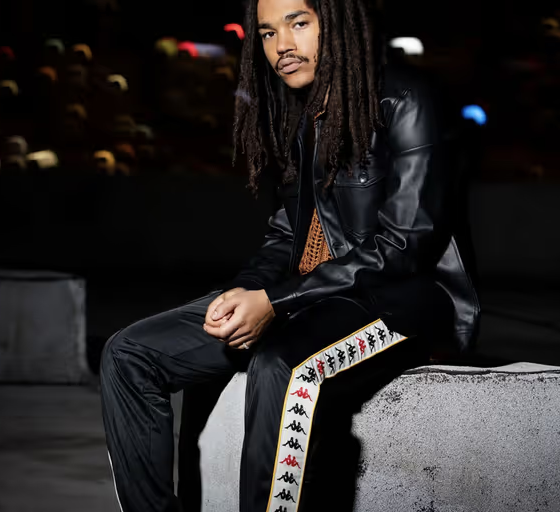 A man wearing a pair of black Kappa pants