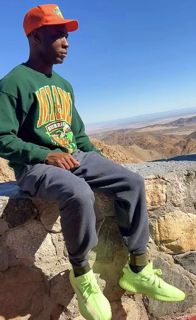 A man wearing a red Bass Pro Shops hat