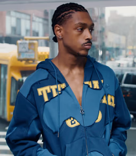 A man wearing a blue TELFAR outfit