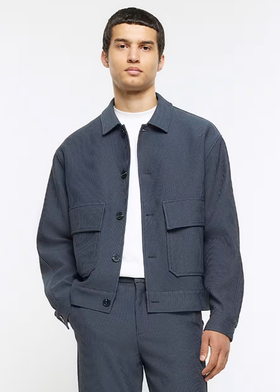 A man wearing a River Island jacket and a white t-shirt