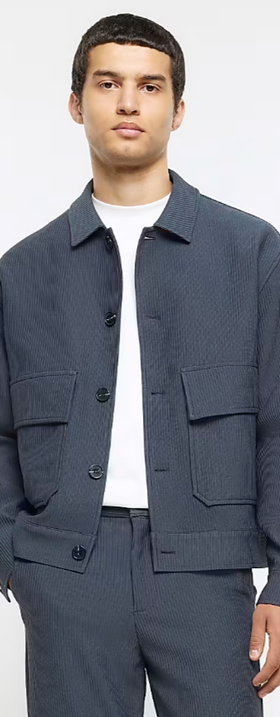 A man wearing a River Island jacket and a white t-shirt