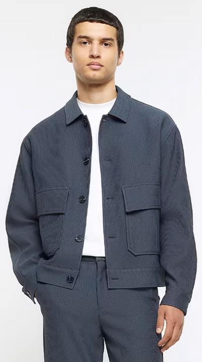 A man wearing a River Island jacket and a white t-shirt