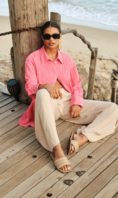 A man wearing a pair of HAVAIANAS and a pink shirt