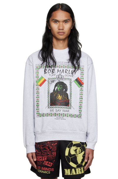 A man wearing a white Bob Marley Online Ceramics t-shirt and matching shorts