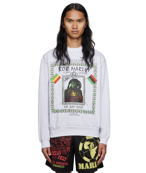 A man wearing a white Bob Marley Online Ceramics t-shirt and matching shorts