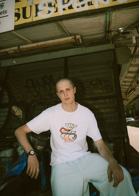 A man wearing a white Triple 5 Soul t-shirt