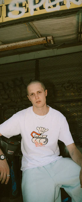 A man wearing a white Triple 5 Soul t-shirt