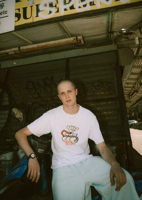 A man wearing a white Triple 5 Soul t-shirt
