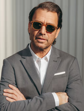 A man wearing a pair of Moscot sunglasses and a grey suit
