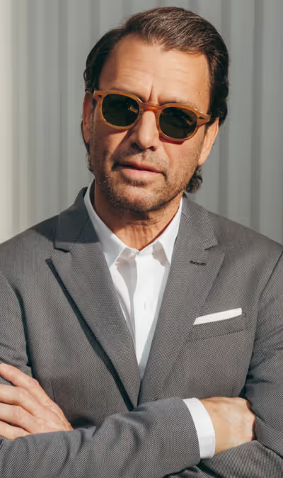 A man wearing a pair of Moscot sunglasses and a grey suit