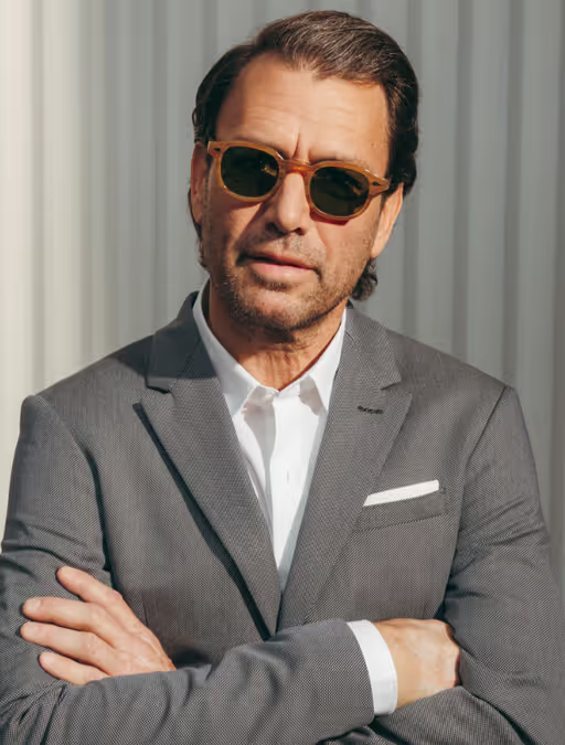A man wearing a pair of Moscot sunglasses and a grey suit