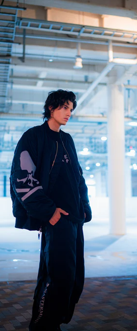 A man wearing a black skulls Mastermind jacket