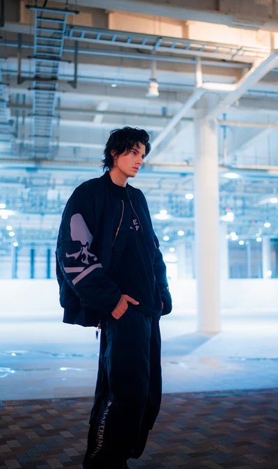 A man wearing a black skulls Mastermind jacket