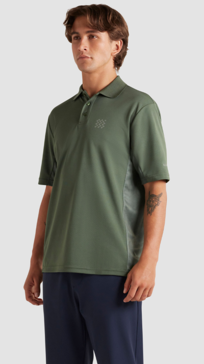 A man wearing a Manors Golf green polo and black pants
