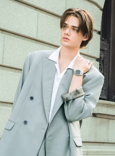 A man wearing a CASIO silver watch and a grey suit