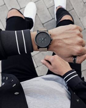 A man wearing a black MVMT watch