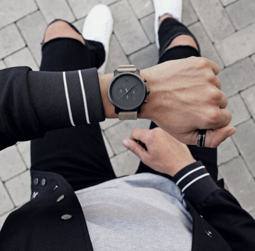 A man wearing a black MVMT watch