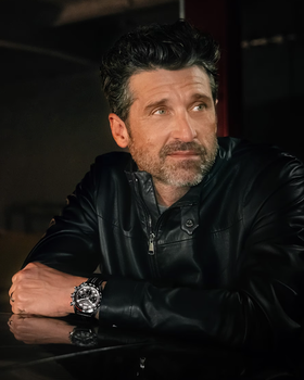 A man wearing a TAG Heuer watch with a black jacket