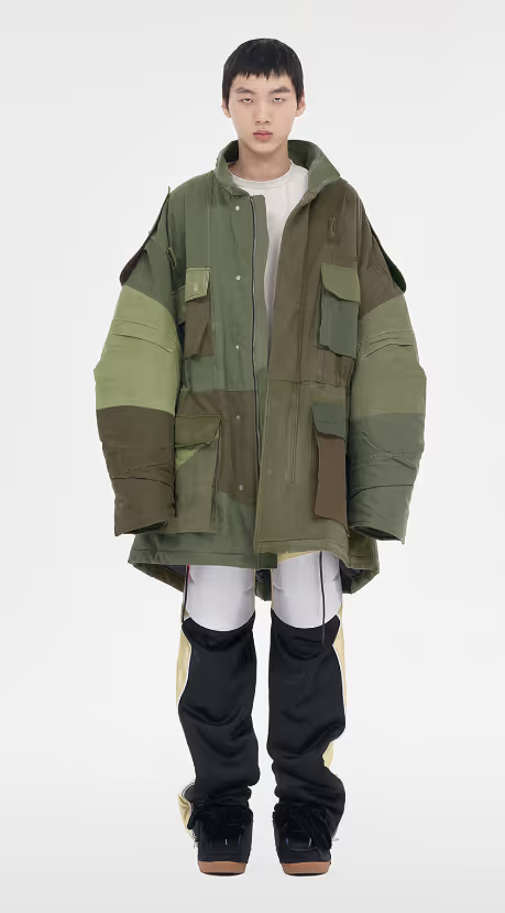 A man wearing a green We11done jacket and a white shirt