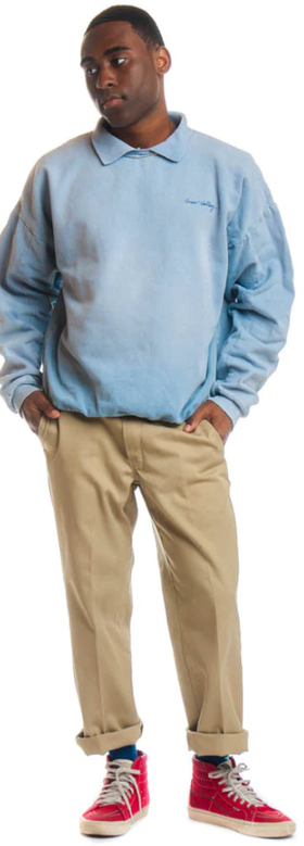 A man wearing a Tunnel Vision powder blue long-sleeve and brown chinos