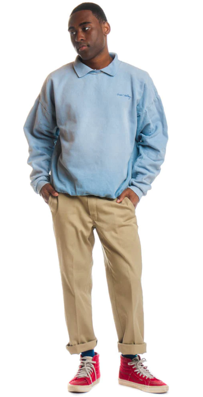 A man wearing a Tunnel Vision powder blue long-sleeve and brown chinos