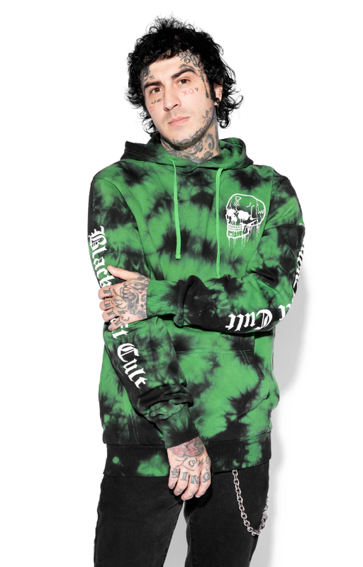A man wearing an acid-green Black Craft Cult hoodie with black pants