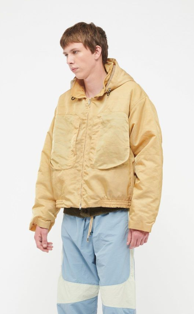 A man wearing a RANRA Studio yellow jacket and blue pants