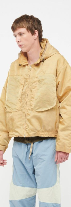 A man wearing a RANRA Studio yellow jacket and blue pants