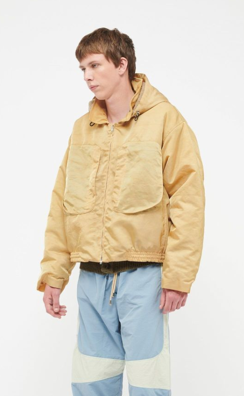 A man wearing a RANRA Studio yellow jacket and blue pants