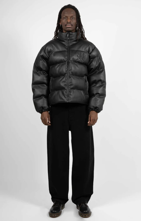 A man wearing a Wasted Paris black puffy coat and black pants