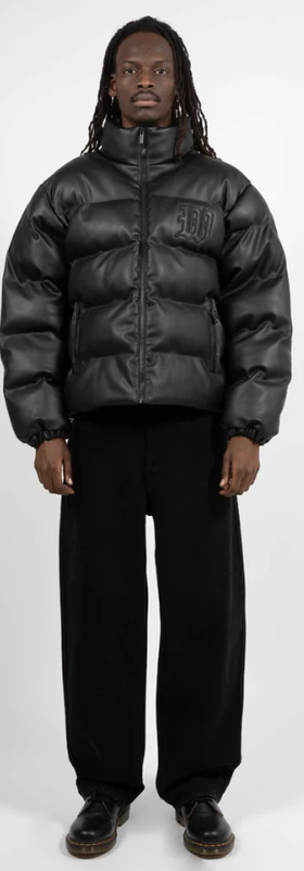 A man wearing a Wasted Paris black puffy coat and black pants