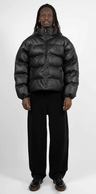 A man wearing a Wasted Paris black puffy coat and black pants