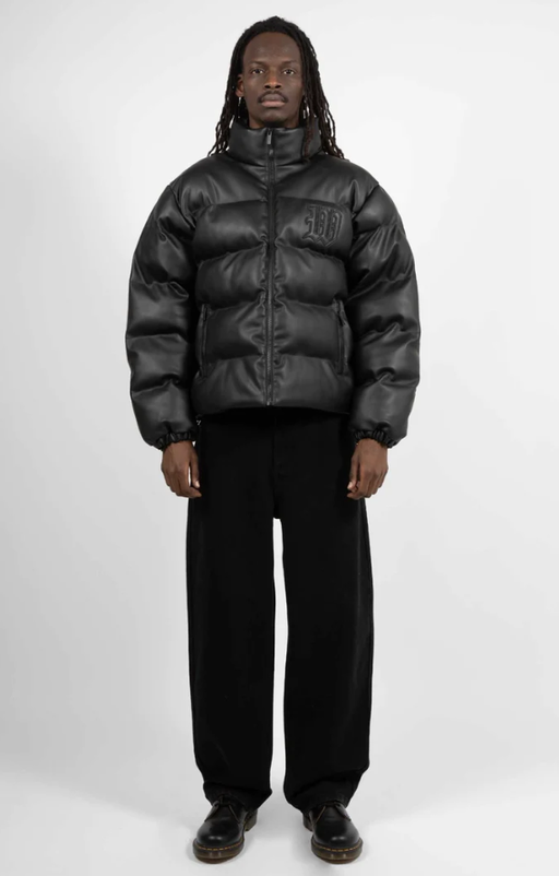A man wearing a Wasted Paris black puffy coat and black pants