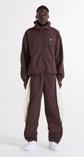 A man wearing a brown Unknown London tracksuit