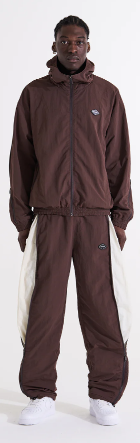 A man wearing a brown Unknown London tracksuit