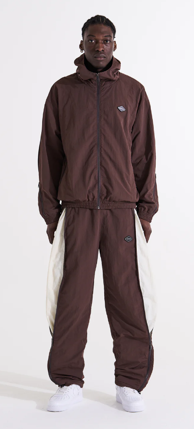 A man wearing a brown Unknown London tracksuit