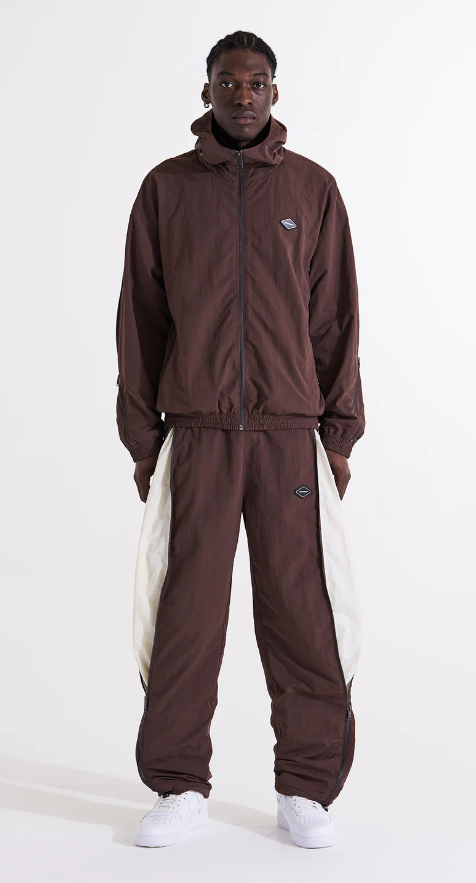 A man wearing a brown Unknown London tracksuit