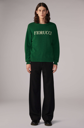 A woman wearing a white Fiorucci logo t-shirt with tight-fitting jeans
