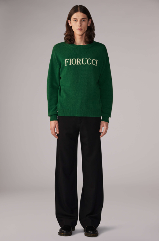 A woman wearing a white Fiorucci logo t-shirt with tight-fitting jeans