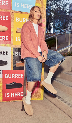 A man wearing a pair Koolaburra shoes in cream