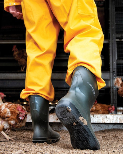 A man wearing a pair of Dunlop Boots with a yellow rain suit