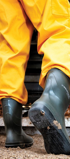A man wearing a pair of Dunlop Boots with a yellow rain suit