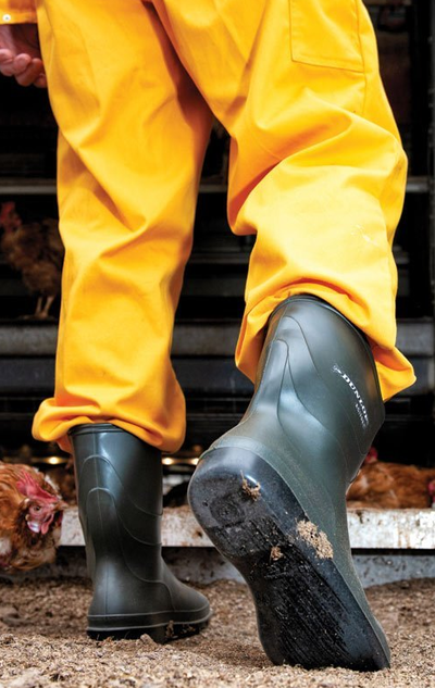 A man wearing a pair of Dunlop Boots with a yellow rain suit