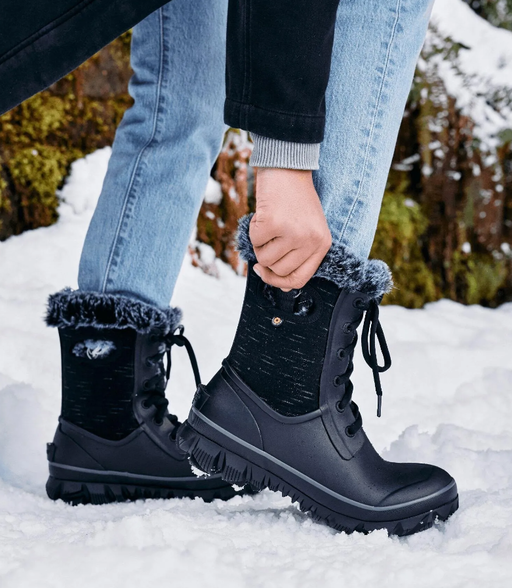 A woman wearing a pair of black Bogs Boots in the snow