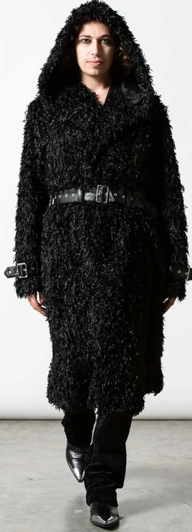 A man wearing an all-black Sourpuss outfit with black boots