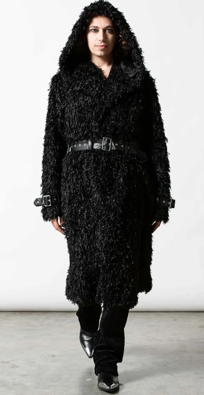 A man wearing an all-black Sourpuss outfit with black boots