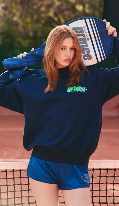 A woman wearing a Sporty & Rich navy/clean mint sweatshirt