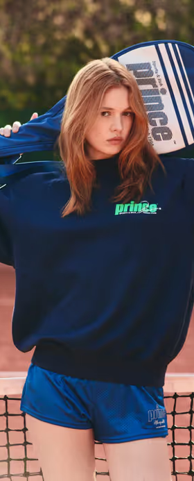 A woman wearing a Sporty & Rich navy/clean mint sweatshirt