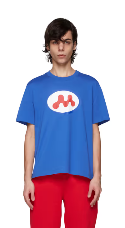 A man wearing a Mowalola blue t-shirt